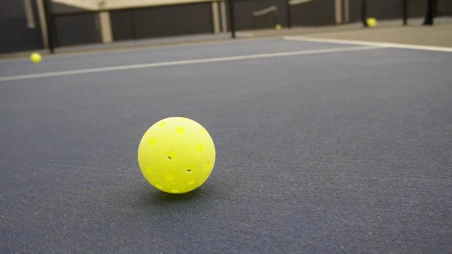 A pickleball resting on an indoor court